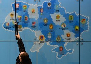 A worker adjusts lights above a tourist map of the Ukraine at the Ukraine stand of the ITB International Travel Trade Fair in Berlin March 4, 2014. The ITB open from March 5 to 9, 2014. TOPSHOTS/AFP PHOTO / JOHN MACDOUGALL