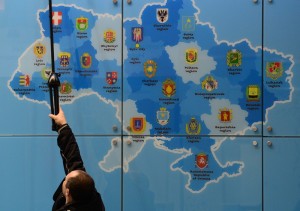A worker adjusts lights above a tourist map of the Ukraine at the Ukraine stand of the ITB International Travel Trade Fair in Berlin March 4, 2014. The ITB open from March 5 to 9, 2014. TOPSHOTS/AFP PHOTO / JOHN MACDOUGALL