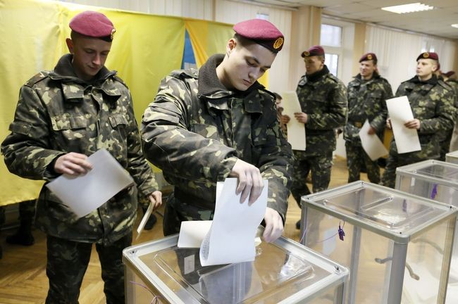 A Ukrainian serviceman casts a ballot during a parliamentary election at a polling station in Kiev