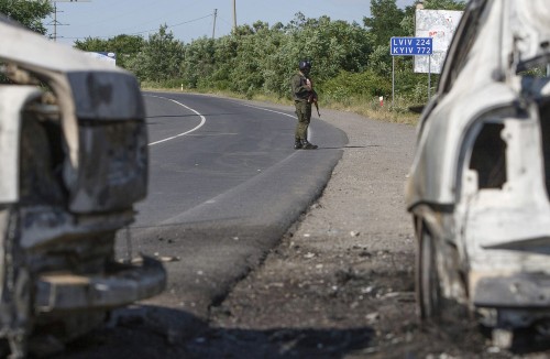 An interior ministry serviceman stands next to burnt cars following a shoot-out in Mukacheve, Ukraine, July 11, 2015. Ukraine's President Petro Poroshenko has instructed law enforcement agencies to disarm and detain those who staged the shoot-out in the town of Mukacheve, Zakarpattia region, which left several people wounded and some reportedly killed, local media reported. REUTERS/Stringer