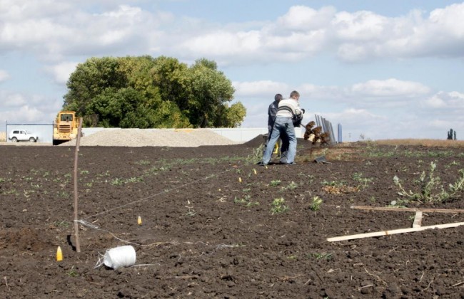 Workers use an auger to drill a hole for a stake to build a fence at a construction site for Russia's new military base near the Russian-Ukrainian border in the village of Soloti, southeast of Belgorod, Russia, September 7, 2015. REUTERS/Anton Zverev