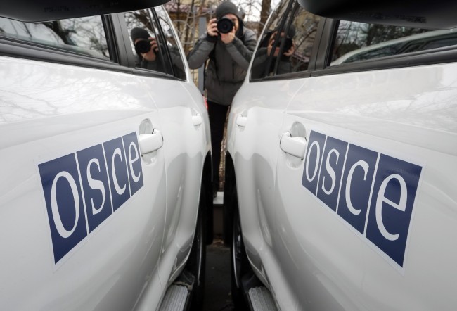 A journalist takes picture during a handover ceremony of ten armoured vehicles donated by Britain to the OSCE Special Monitoring Mission (SMM) to Ukraine, in Kiev January 13, 2015. REUTERS/Gleb Garanich (UKRAINE - Tags: POLITICS CIVIL UNREST TRANSPORT)